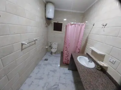 a bathroom with a sink and a pink shower curtain at Emad villa in Hurghada