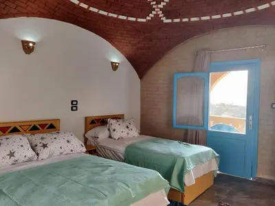 a room with two beds and a window at Nubian Hights guesthouse in Shellal