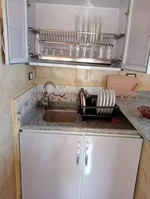a kitchen counter with a sink and a microwave at Nubian Hights guesthouse in Shellal