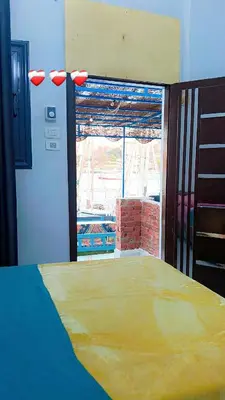 a room with a bed and a large window at Onaty Narty Guest house Nile view in Aswan