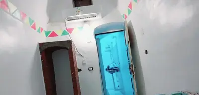 a hallway with a blue door and a mirror at Nubian Amego Gaust House in Aswan