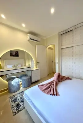 a bedroom with a bed and two stools in it at SunShine Y1-1-19 in Hurghada