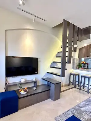 a living room with a blue couch and a staircase at SunShine Y1-1-19 in Hurghada