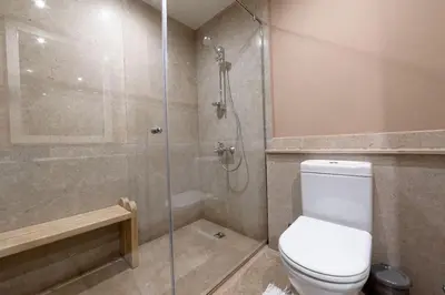 a bathroom with a toilet and a glass shower at Sabina Lagoon view 2BR Apartment in Hurghada
