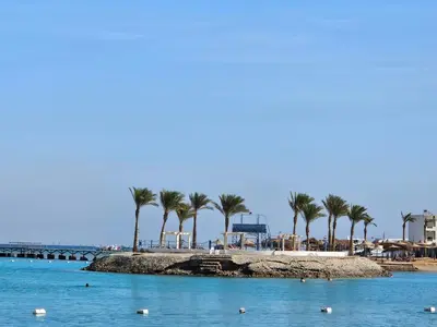 a beach with palm trees and a pier at Noura Luxury Hotel Villa with free Pool and Beach access in Hurghada in Hurghada