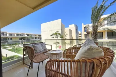 a balcony with wicker chairs and a table on a balcony at The Snuggly Studio G Cribs El Gouna in Hurghada