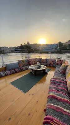 a deck with couches and a coffee table on a boat at Freedom Houseboat in Aswan
