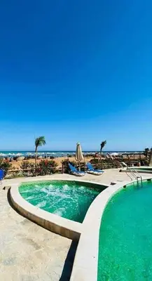 a swimming pool with the beach in the background at Turtles Beach resort hourghada Studio view sea view pool private beach Pools balcony security Cafe and restaurant on pool jacuzzi air-condition sunny a large balcony in Hurghada