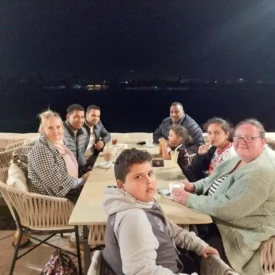 a group of people sitting at a table at Lemon Tree apartments luxor in Al Aqālitah