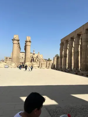 a young boy standing in front of a building at Lemon Tree apartments luxor in Al Aqālitah