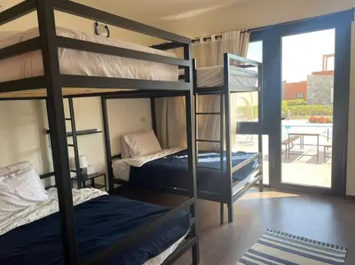 two bunk beds in a room with a patio at Baywest Villa, Somabay in Safaga