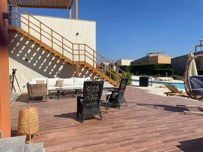 a group of chairs sitting on a patio with a staircase at Baywest Villa, Somabay in Safaga
