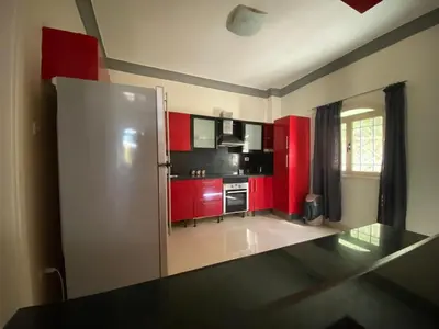 a kitchen with red cabinets and a stainless steel refrigerator at Hurghada-Magawish Villa 6 in Hurghada
