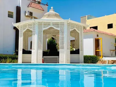 an outdoor gazebo next to a swimming pool at فيلا 1☆ in Hurghada