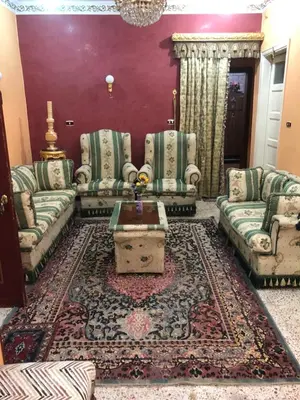 a living room with couches and a table on a rug at Dr milad shokralla multiple central flats in Luxor