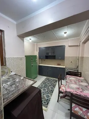 a kitchen with a table and a green refrigerator at Dr milad shokralla multiple central flats in Luxor