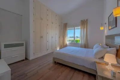 a white bedroom with a bed and a window at unique flat_ garden and lagoon in Hurghada