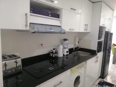 a white kitchen with a sink and a stove at Selena Bay Resort & beach in Hurghada