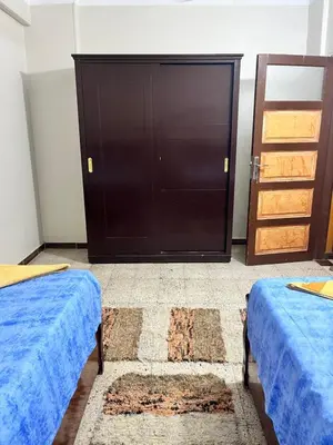 a bedroom with two beds and a black door at NUB Guest House in Aswan