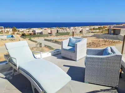 a balcony with two chairs and a view of the ocean at Modern Soma Bay 2BR Villa w sea views, beach & pool access in Hurghada