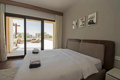 a bedroom with a bed with a view of a patio at Ollystays Fanadir Marina 1BR Heated Jacuzzi in Hurghada