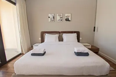 a bedroom with a large white bed with two pillows at Ollystays Fanadir Marina 1BR Heated Jacuzzi in Hurghada