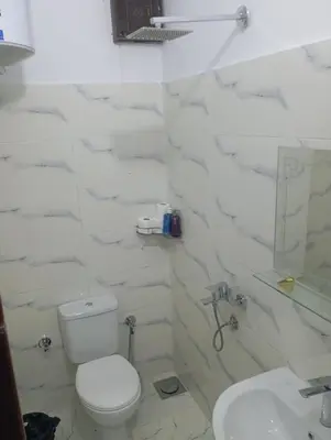 a white bathroom with a toilet and a sink at Abeer Guest House in Luxor