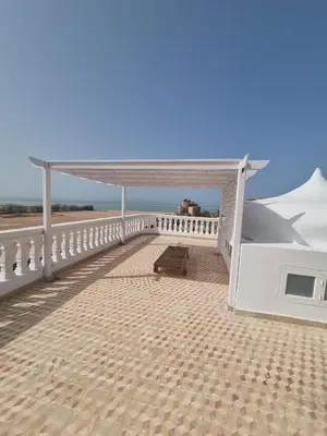 a white pavilion with a bench on a beach at White House Hurghada in Hurghada