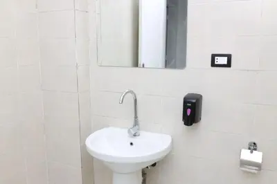 a white bathroom with a sink and a mirror at Diamond Guest House in Luxor