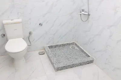 a white bathroom with a toilet and a shower at Diamond Guest House in Luxor
