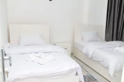 two beds in a room with white sheets at Diamond Guest House in Luxor