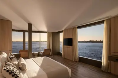 a bedroom with a large bed with a view of the water at STORIA THE DAHABEYA - Mondays from Luxor for 4 & 7 Nights, and Fridays from Aswan for 3 & 7 Nights - Available for Private Bookings in Luxor