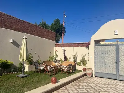 a patio with an umbrella and a table and chairs at West Bank luxury villa in Luxor