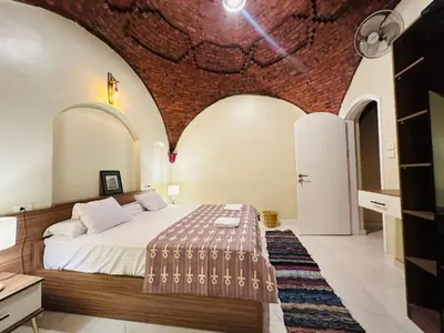 a bedroom with a bed and a brick wall at West Bank luxury villa in Luxor