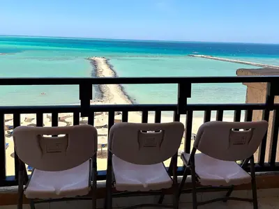 two chairs sitting on a balcony overlooking the ocean at Hurghada Concierge at Turtles Beach Resort in Hurghada