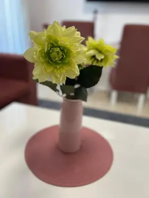 a vase with yellow flowers in it on a table at Selena Bay Hurghada - Pink Apartment in Hurghada