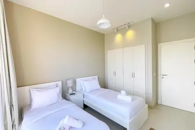 two beds in a small room with white furniture at Homey 3 BDR Townhouse Tawila El Gouna in Hurghada