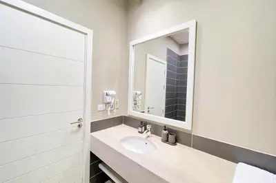 a bathroom with a sink and a mirror at Homey 3 BDR Townhouse Tawila El Gouna in Hurghada