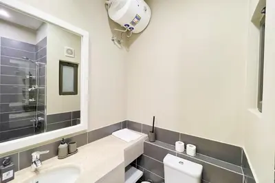 a bathroom with a sink and a mirror and a toilet at Homey 3 BDR Townhouse Tawila El Gouna in Hurghada