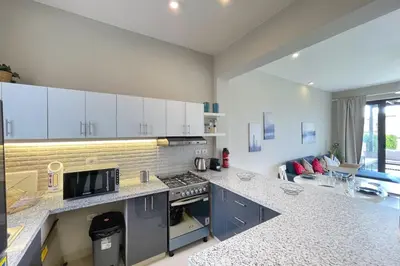 a kitchen with white cabinets and a counter top at Homey 3 BDR Townhouse Tawila El Gouna in Hurghada