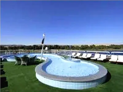 a large swimming pool with lounge chairs around it at Royal Cruise Aswan to Luxor 3 Night And visit the Nubian village in Luxor