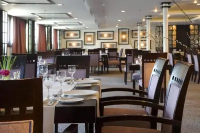 a dining room with tables and chairs with wine glasses at Royal Cruise Aswan to Luxor 3 Night And visit the Nubian village in Luxor