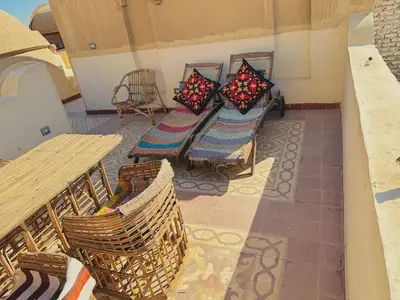 a balcony with chairs and a table and a bench at Ramses Apartment in Luxor