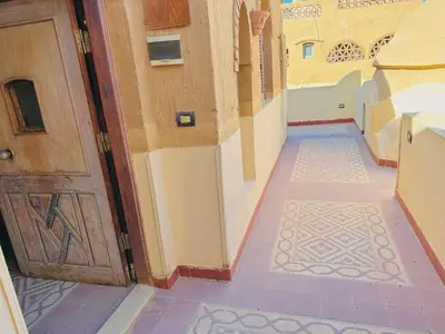 an empty hallway with a door and a tile floor at Ramses Apartment in Luxor