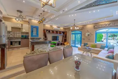 a living room with a table and chairs and a kitchen at Spacious villa with private pool in Hurghada