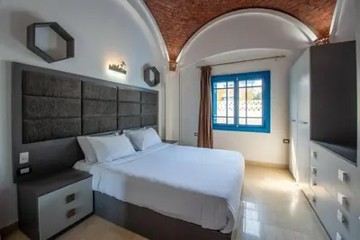 a bedroom with a large white bed and a window at Spacious villa with private pool in Hurghada