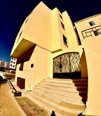 a building with stairs leading to a doorway with a door at hurghada home in Safaga