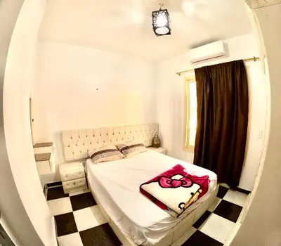 a bedroom with a bed in a room with a window at hurghada home in Safaga