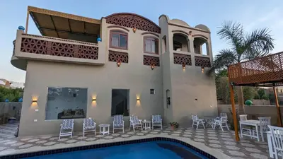 a house with a swimming pool in front of it at Yasmine Guest House in Luxor