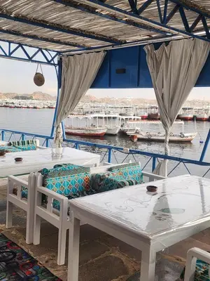 a table and chairs on a boat in the water at Endo Mando in Shellal